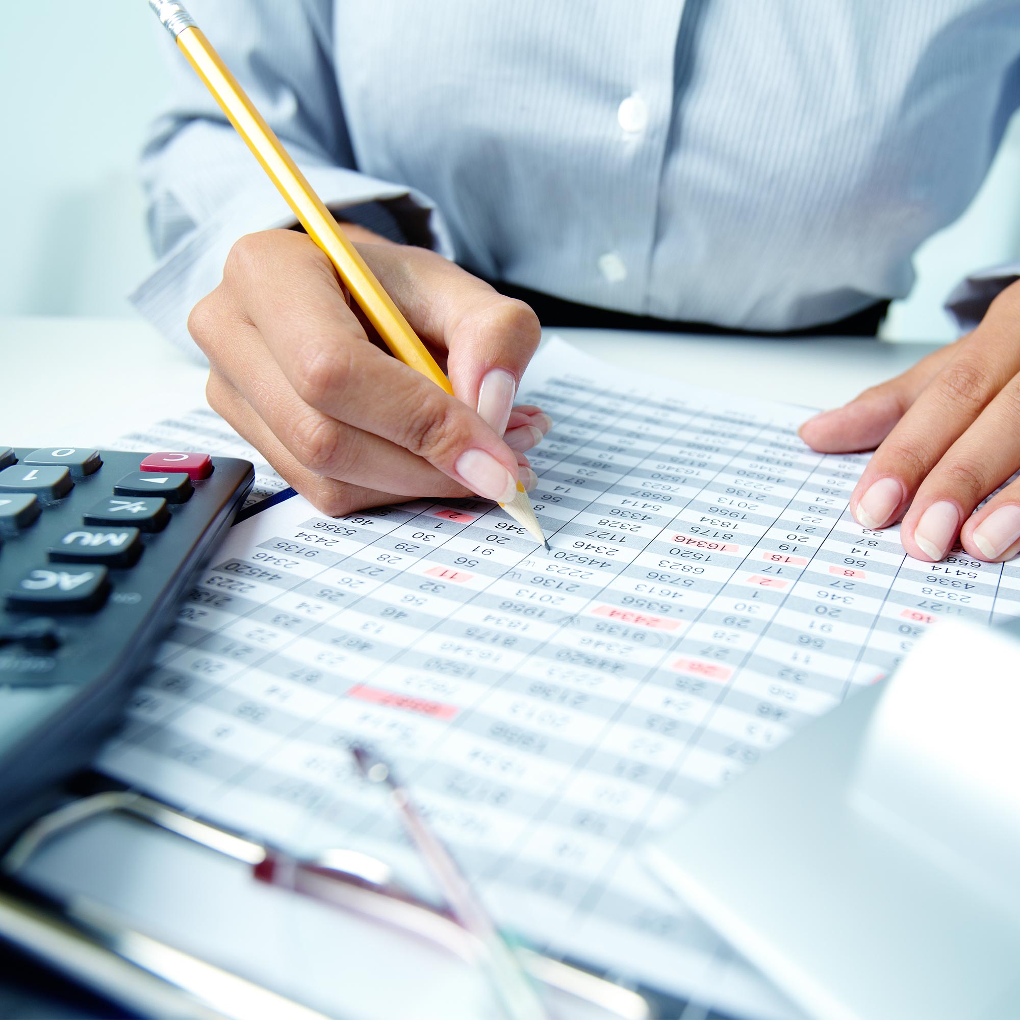 Accountant business woman's hands. Counting numbers with calculator and a pencil in hands. Accounting, tayes and payroll services.